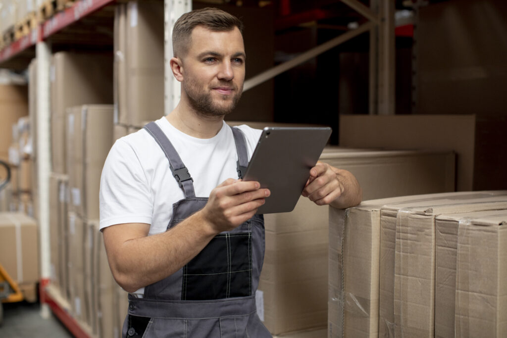 Mann am Tablet in einer Lagerhalle